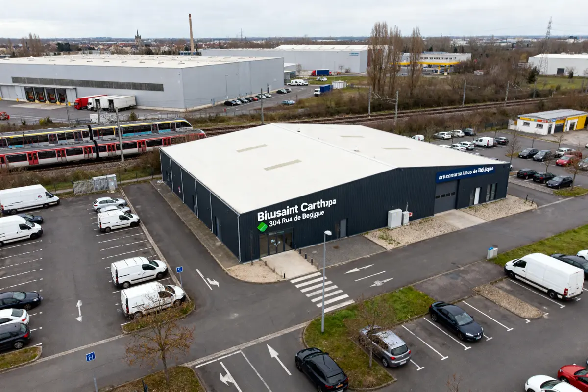 Bâtiment industriel avec parking et train à proximité, hub Lieusaint carte visible